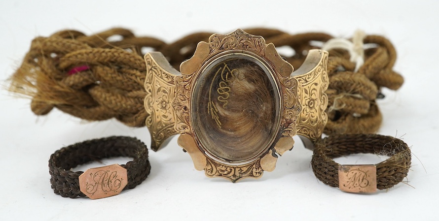 A Victorian yellow metal mounted plaited hair bracelet and two similar rings. Condition - poor